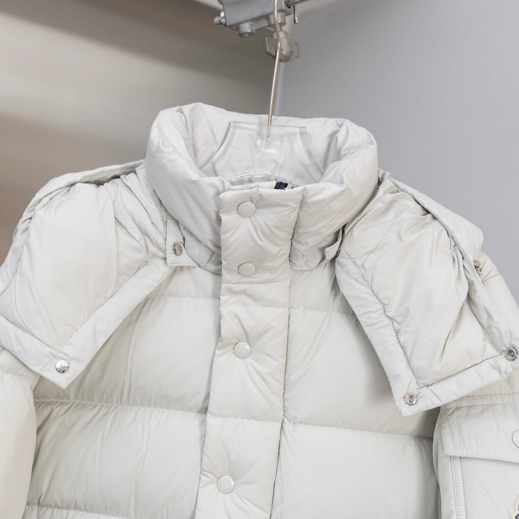 White puffer jacket with hood, snap buttons, and quilted shoulder sections