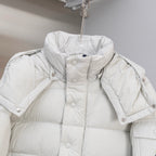 White puffer jacket with hood, snap buttons, and quilted shoulder sections