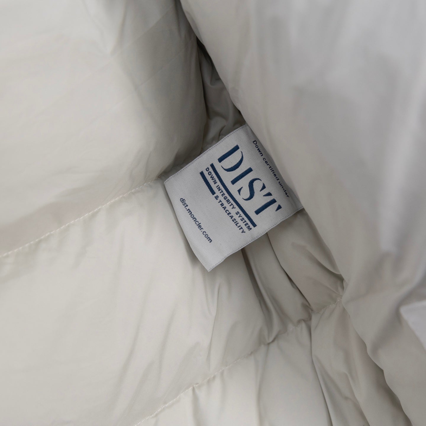 White puffer jacket lining with blue fabric care label tag