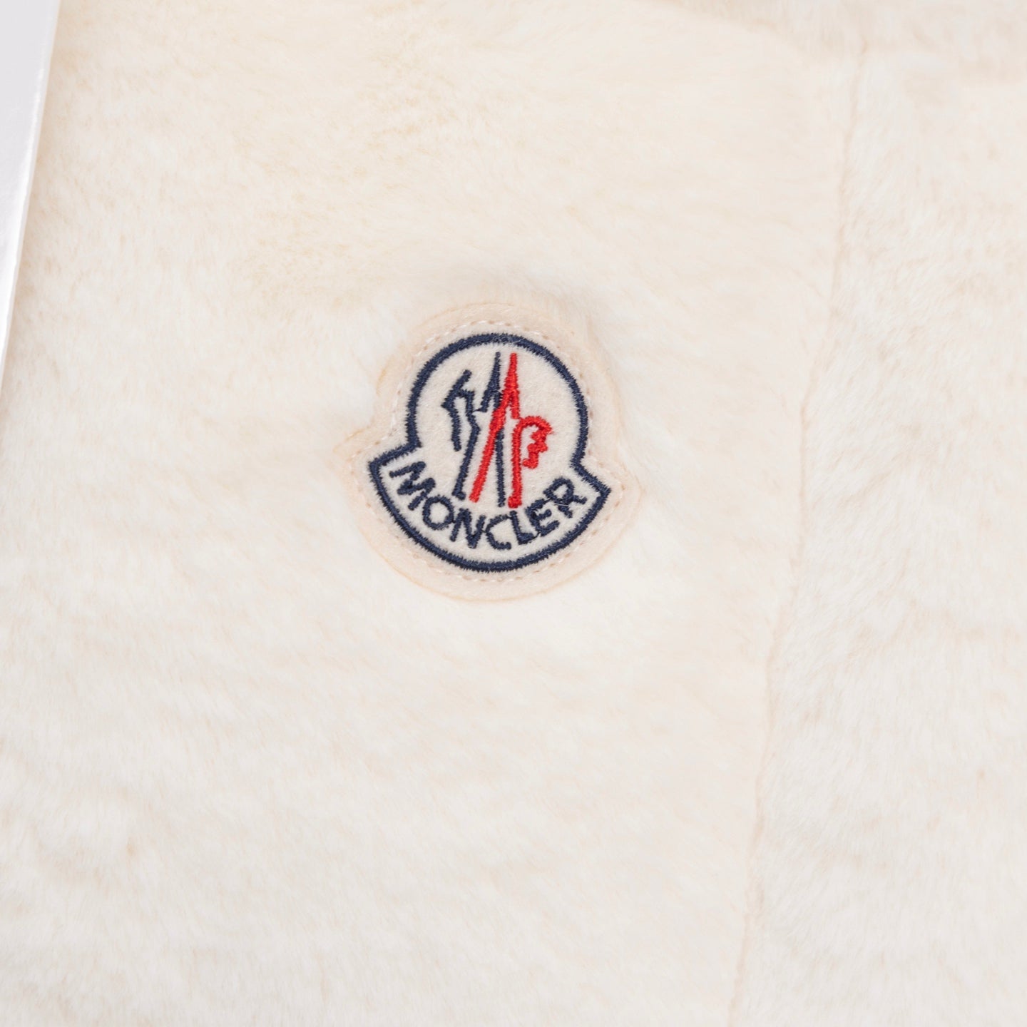 Moncler round logo patch on cream padded vest fabric