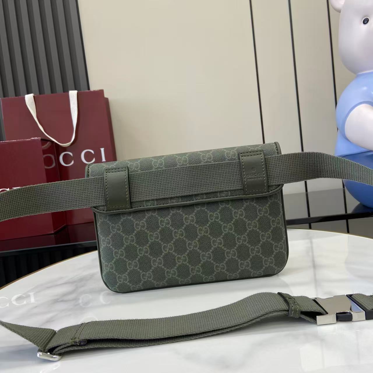 Green Gucci GG monogram bag with flap and adjustable web strap, front view.