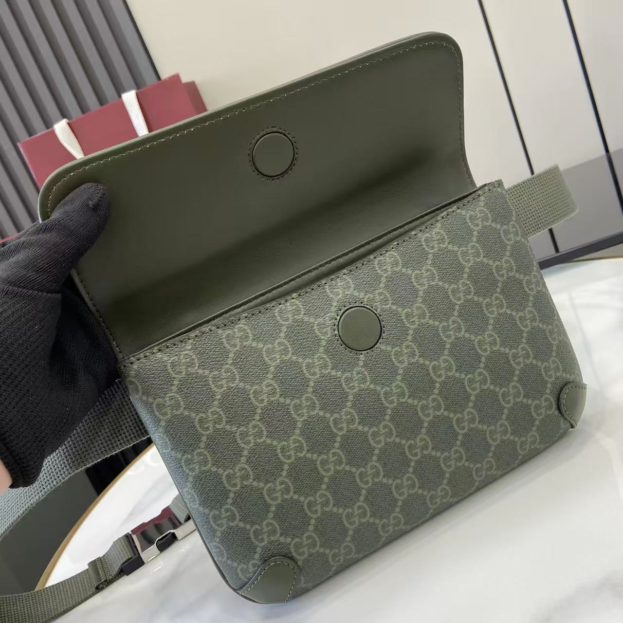 Gucci bag interior view: khaki lining and green exterior with snap details.