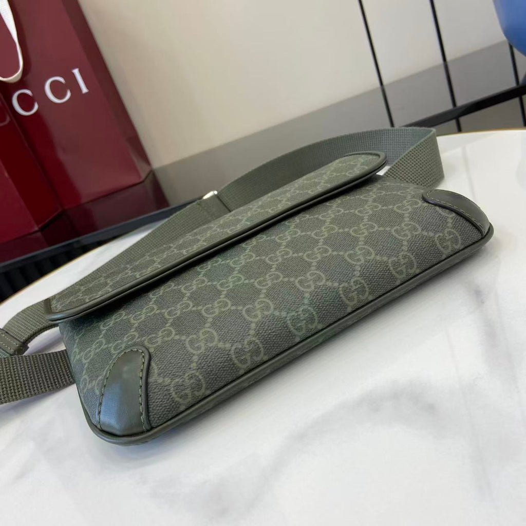 Gucci bag with GG monogram canvas, green, laid on table with long strap.