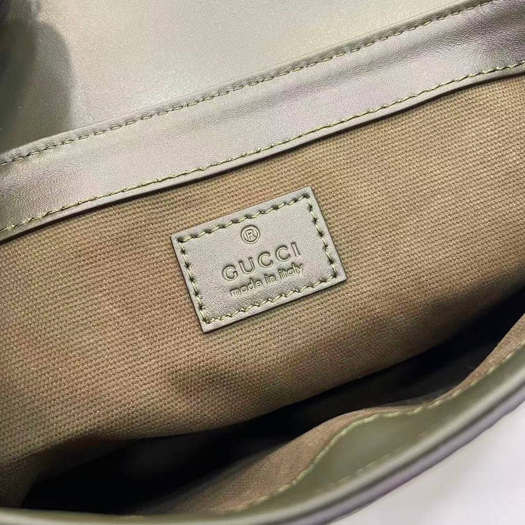 Gucci bag exterior logo patch with 'Gucci' and 'made in Italy' text.