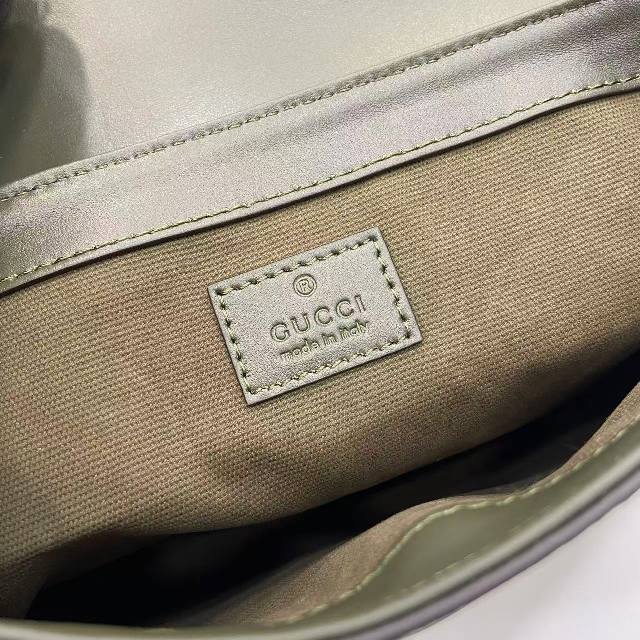 Gucci bag exterior logo patch with 'Gucci' and 'made in Italy' text.