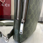 Gucci bag close-up: dark green monogram front with zip pull and silver logo plate