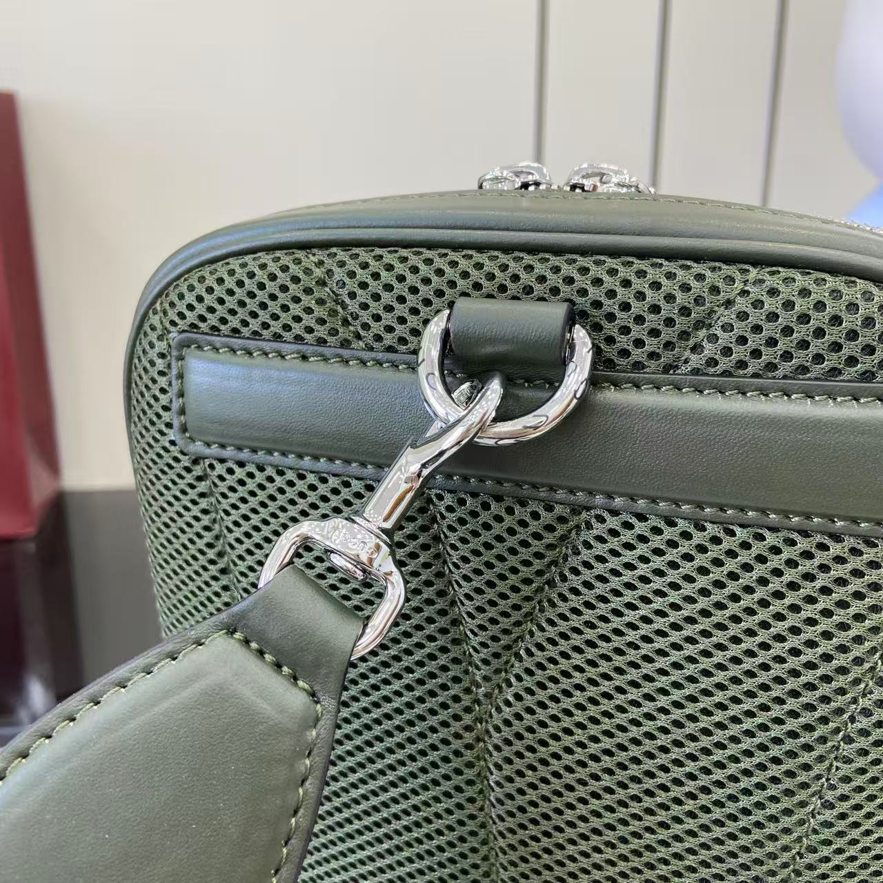 Gucci bag clasp with green mesh panel and silver-tone hardware, top close-up