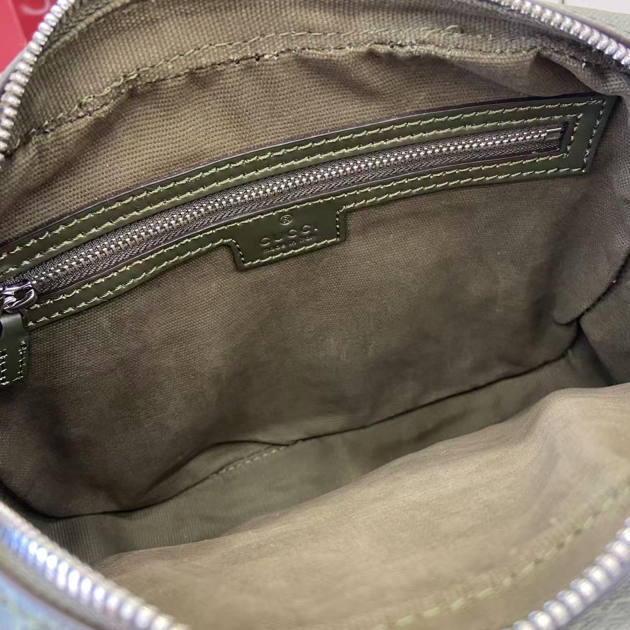 Crossbody bag interior lining with stitched pocket edge and zip track close-up