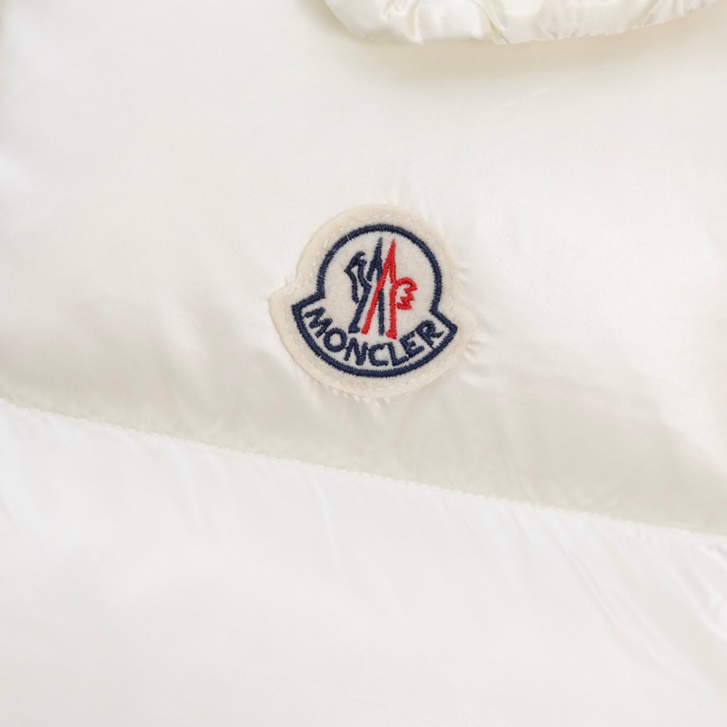 Embroidered Moncler logo patch on white padded jacket