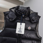 Black quilted puffer vest with hood, front zipper, and logo patch
