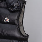 Black quilted puffer vest with logo patch and buttoned shoulder detail