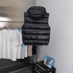 Quilted long puffer vest in black with hood, front zip, and stitch rows