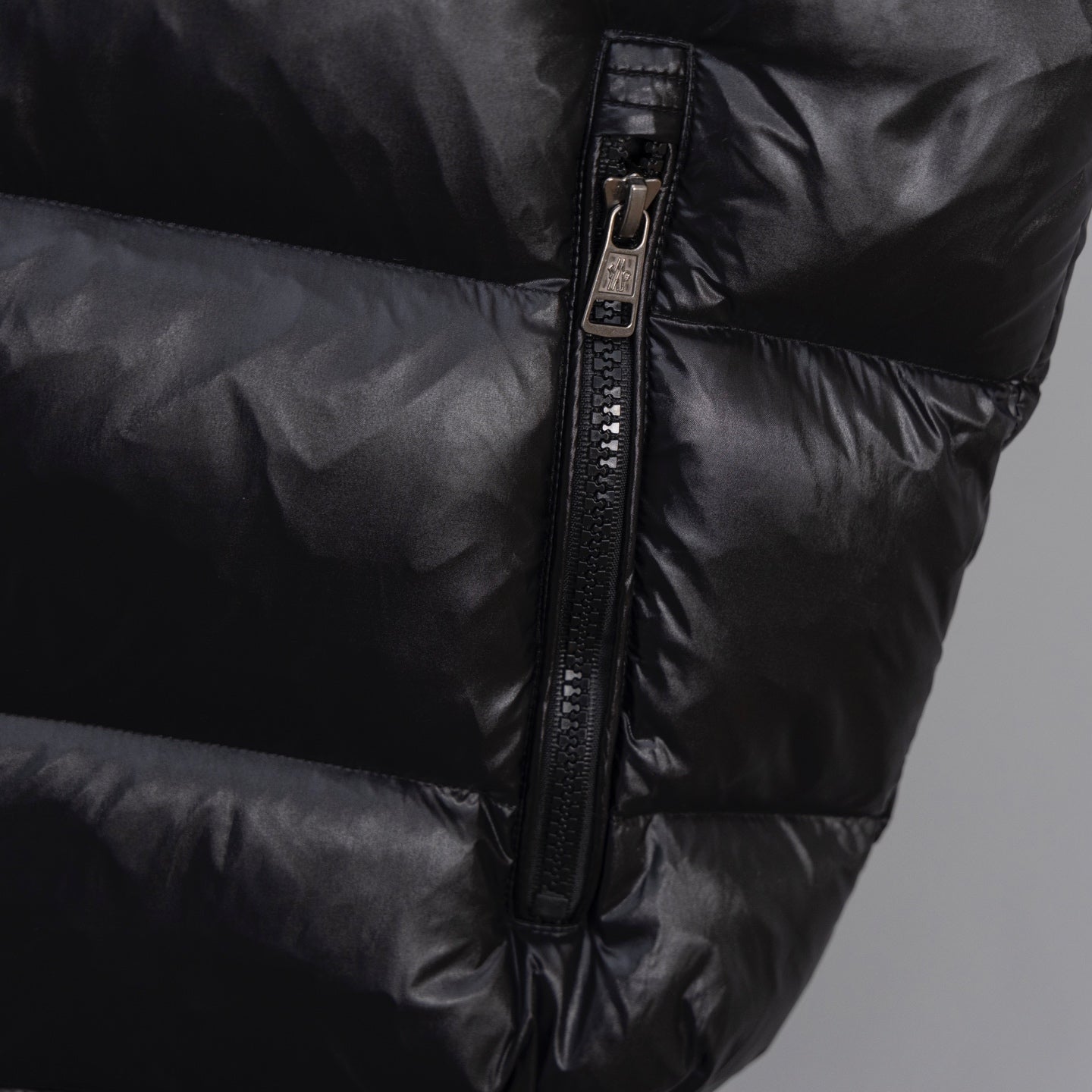 Moncler long puffer jacket, front zipper detail on dark outerwear
