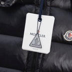 Black puffer vest fabric close-up with circular Moncler logo patch and tag