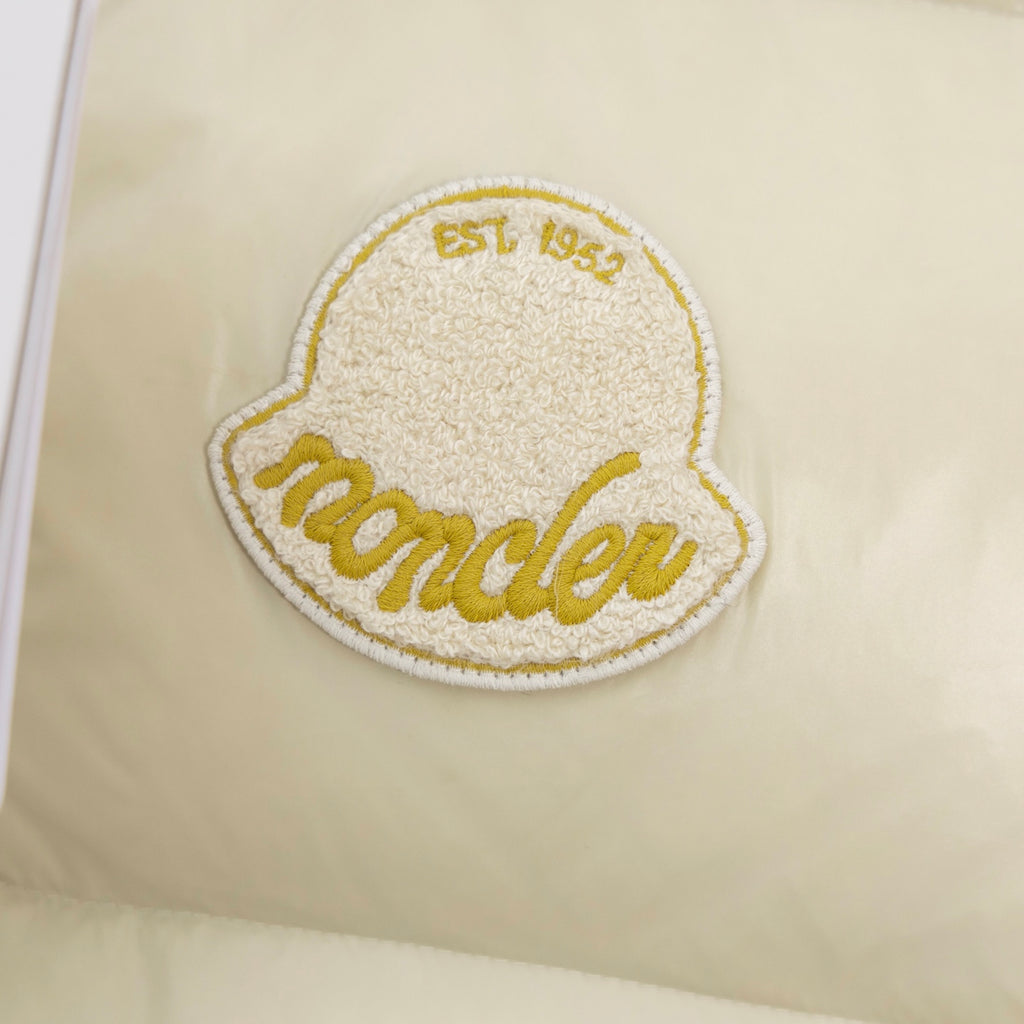 Cream padded vest with oval embroidered 'Moncler' logo patch in gold
