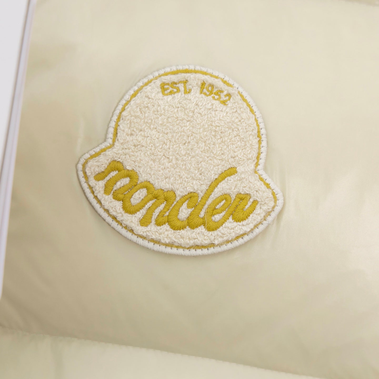 Cream padded vest with oval embroidered 'Moncler' logo patch in gold