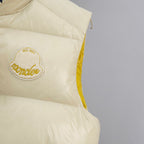 Cream padded vest side with oval embroidered logo patch and yellow piping