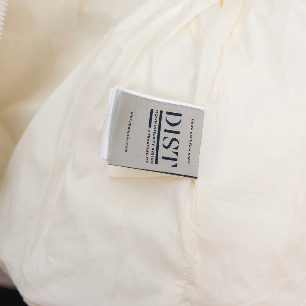 Moncler long puffer jacket care label tag on cream fabric