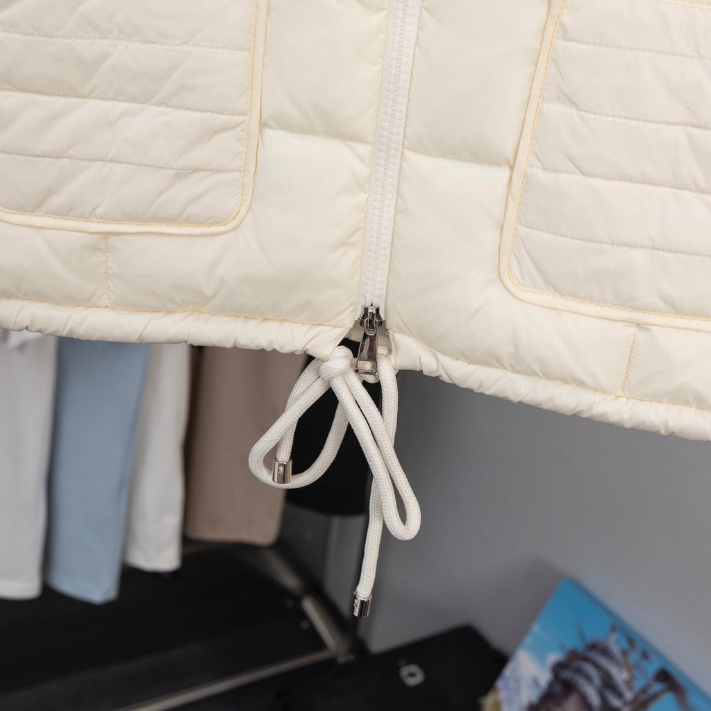 Moncler long puffer jacket, cream front zipper and drawcord close-up