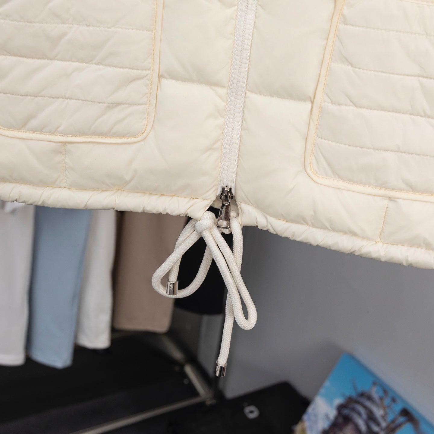 Moncler long puffer jacket, cream front zipper and drawcord close-up