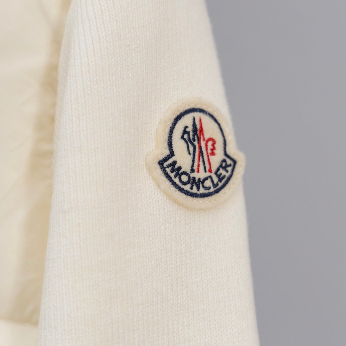 Moncler sleeve logo patch on cream ribbed cuff