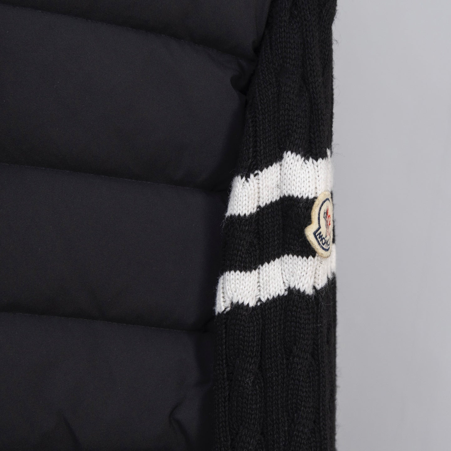 Moncler puffer jacket sleeve with striped knit cuff and round logo patch