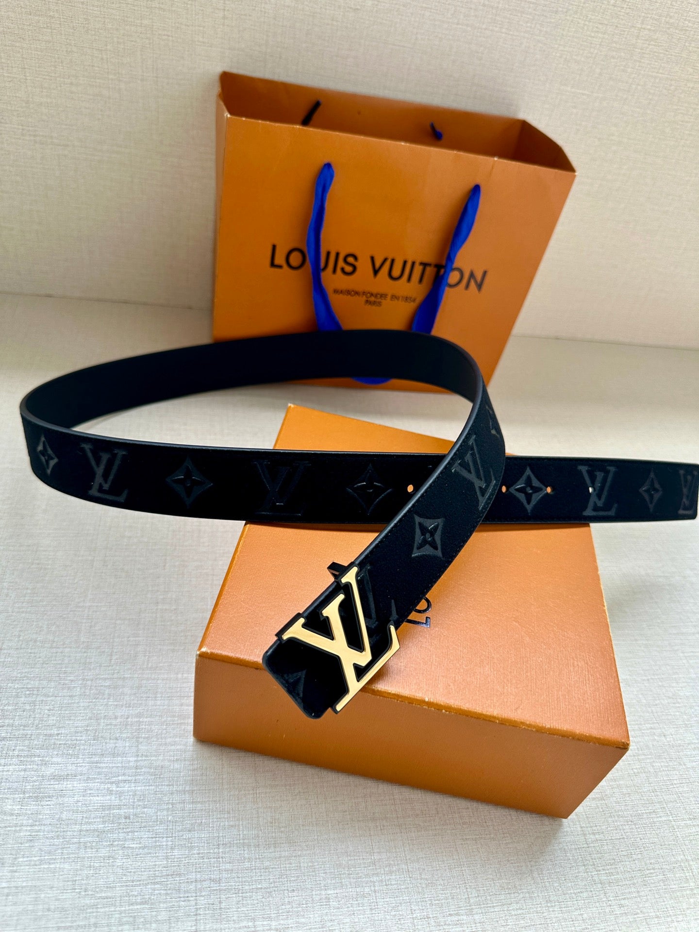 Louis Vuitton dark navy belt with monogram pattern and LV buckle, end visible