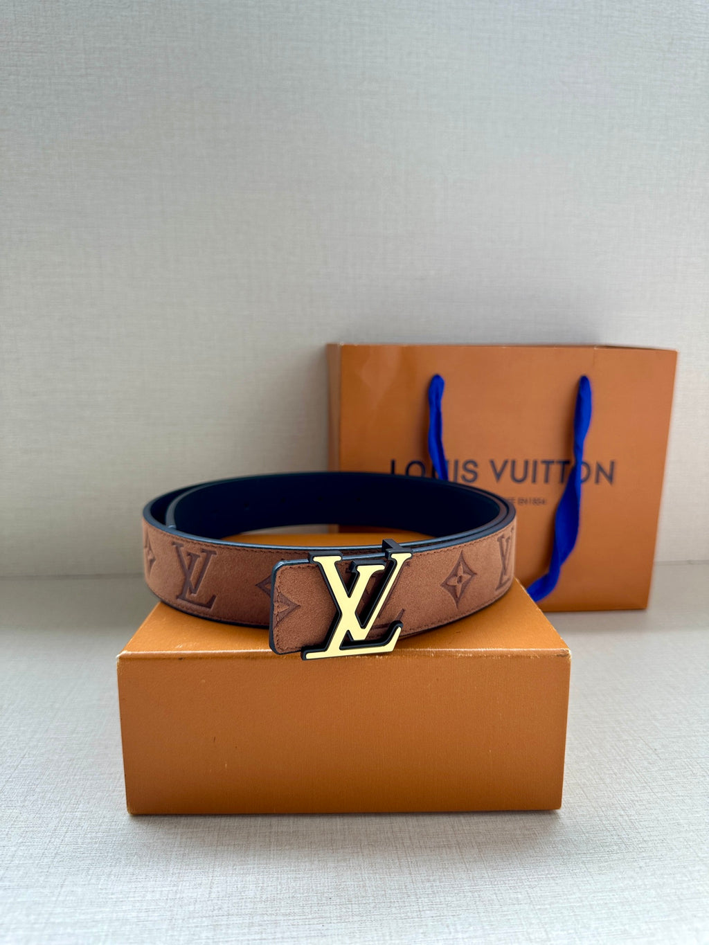 Tan monogram belt with gold LV buckle and blue lining