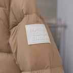 Beige puffer jacket sleeve with Burberry London England logo patch