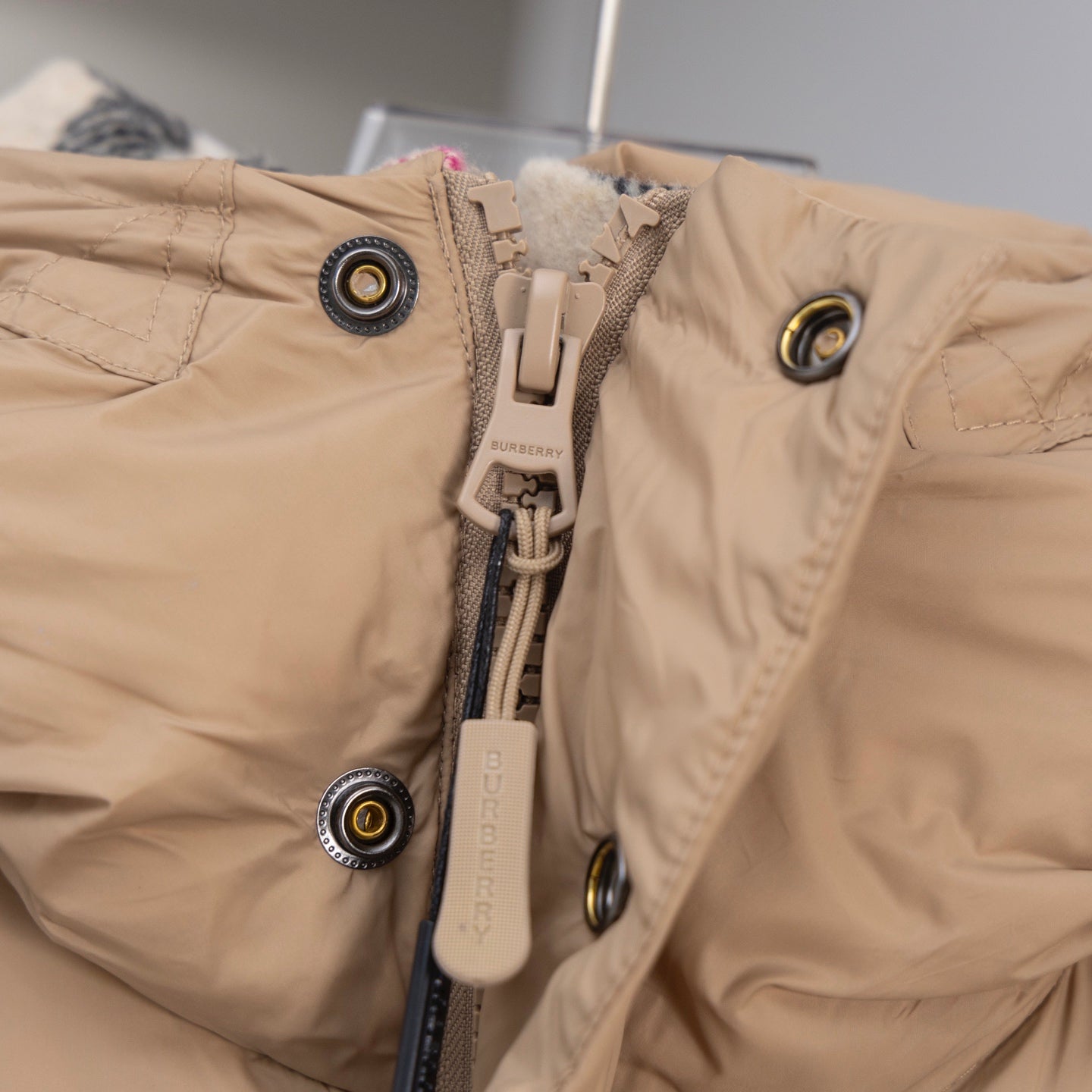 Beige puffer jacket front with zipper, snap buttons, Burberry detail