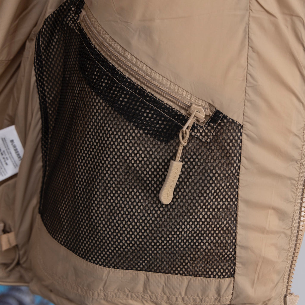 Beige puffer jacket with black mesh interior pocket and zip closure