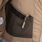 Beige puffer jacket with black mesh interior pocket and zip closure
