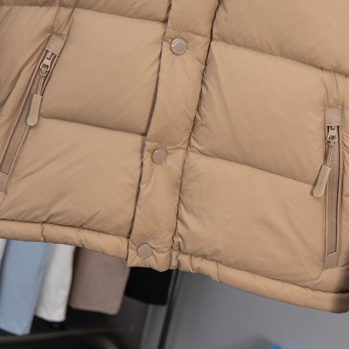 Beige puffer jacket with buttoned front and full-zip pockets
