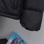 Black puffer jacket sleeve and hem close-up with textured quilted panels