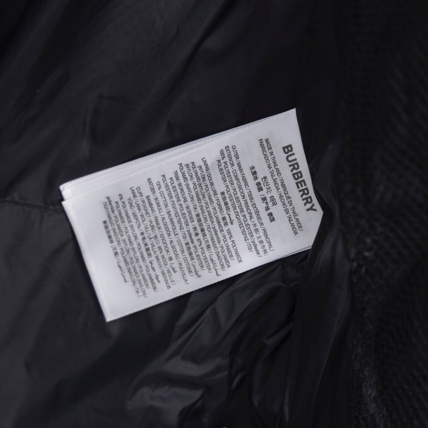 Burberry fabric care label inside dark puffer jacket lining