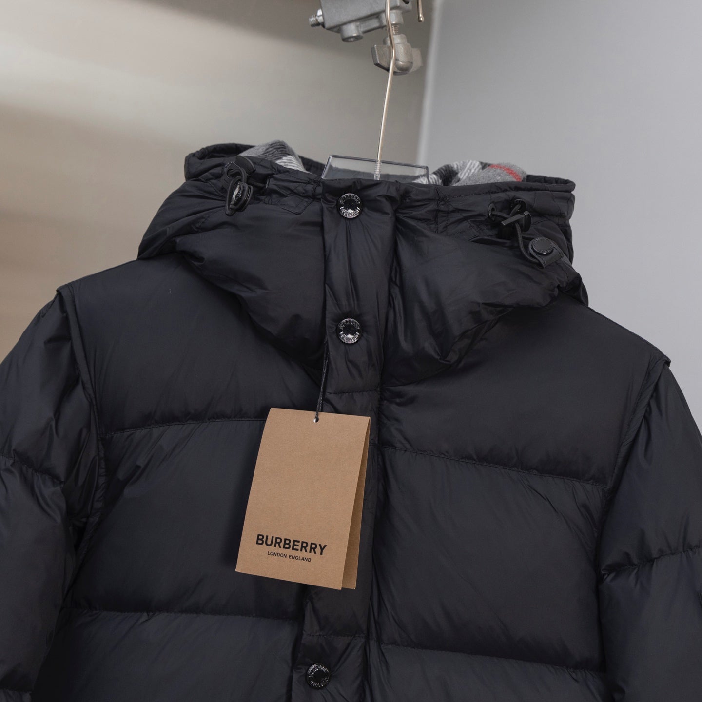 Black hooded puffer jacket with button front and attached hood detail