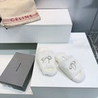 White fuzzy slide sandals with rhinestone bow strap, paired shoes
