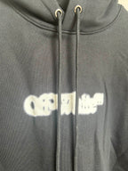 Black hoodie close-up of drawstring hood and small logo print on chest