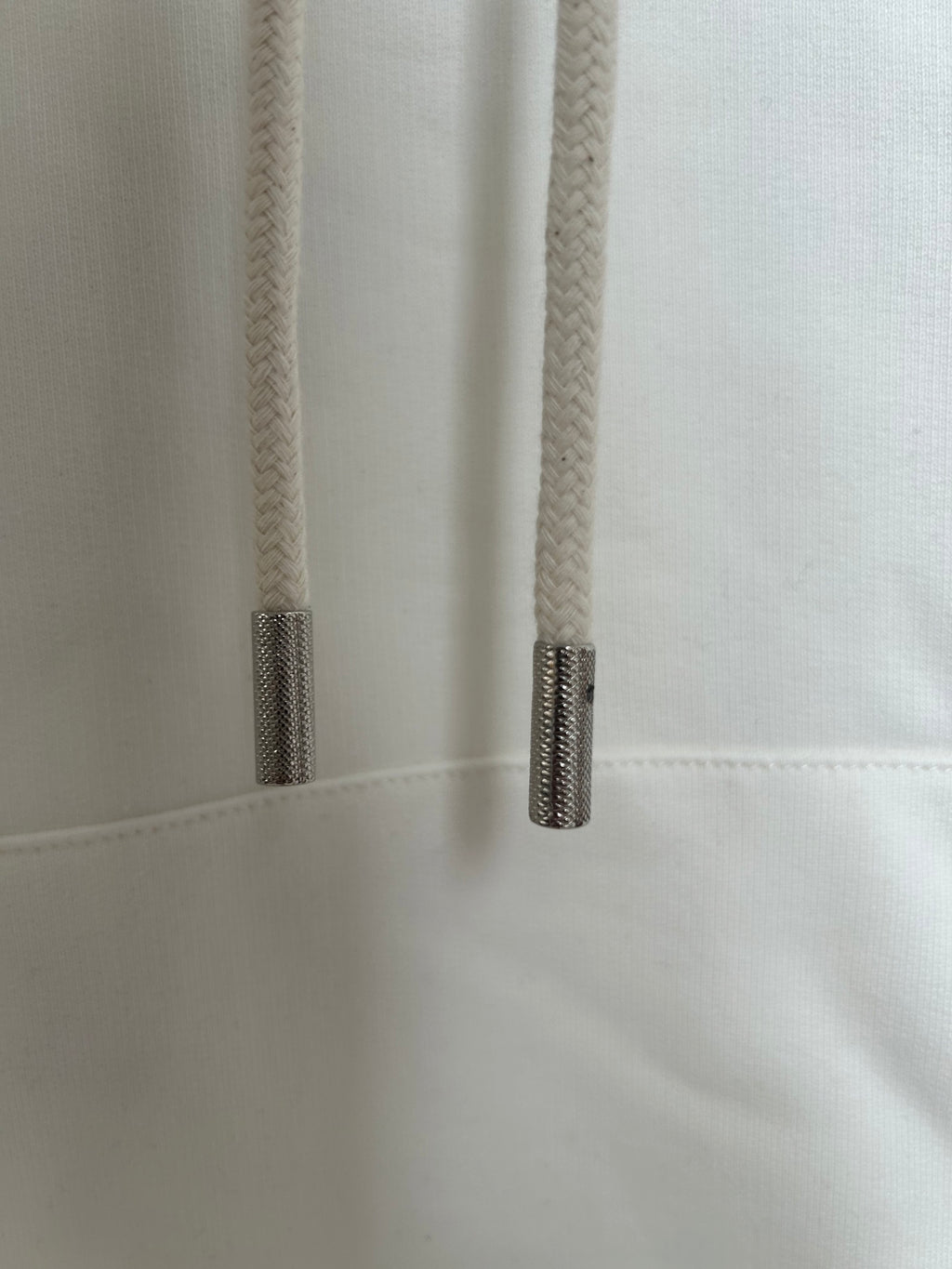 Off-white hoodie close-up of drawstring tips and stitched seam near pocket