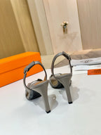 Hermes heeled sandals with light gray slingback straps and sculpted block heel