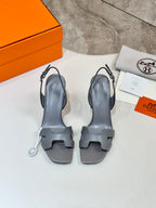 Light blue-gray heeled sandals, front view, with slingback straps and cutout sole