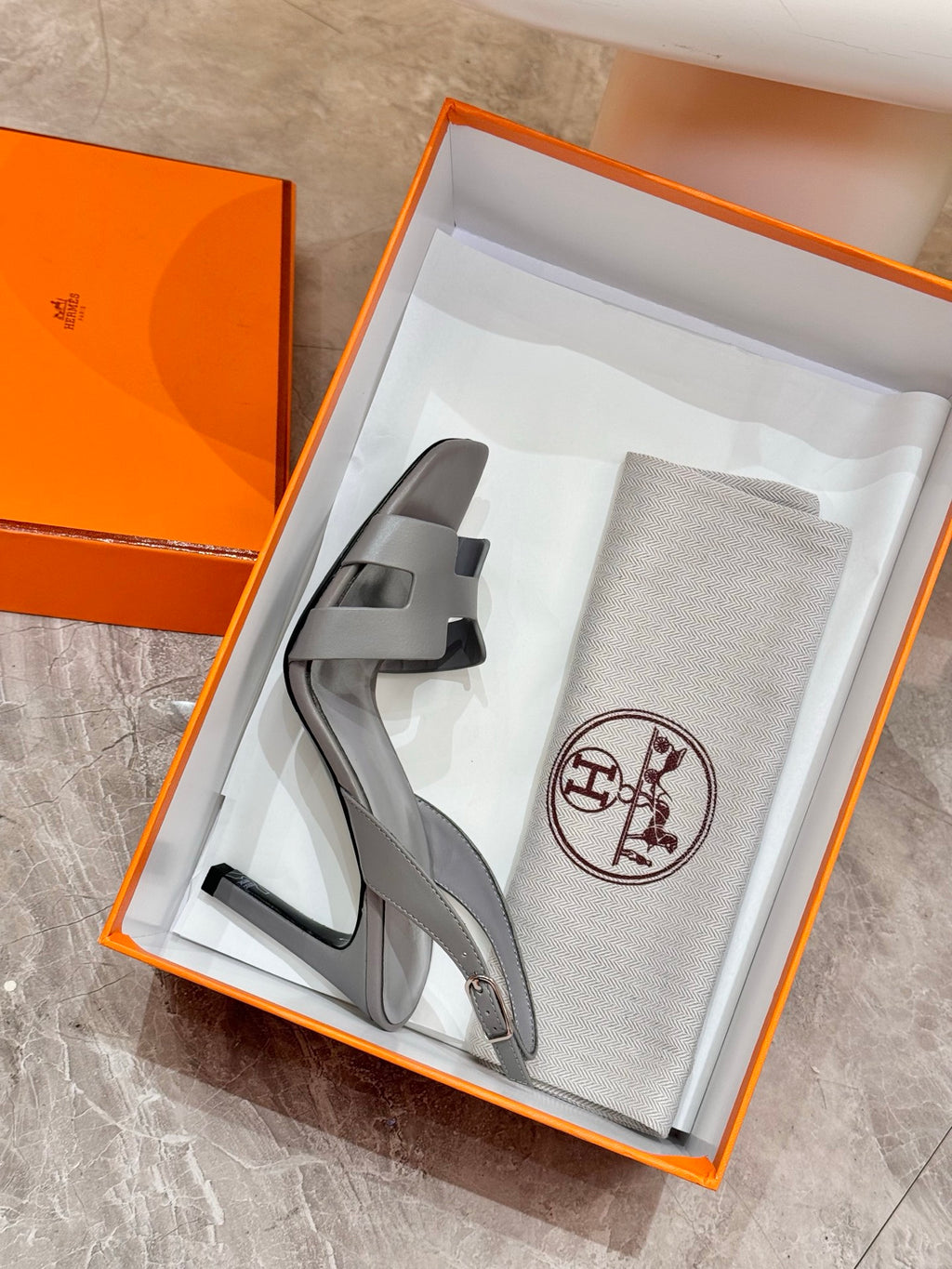 Light blue-gray heeled sandals in a retail box with dust bag