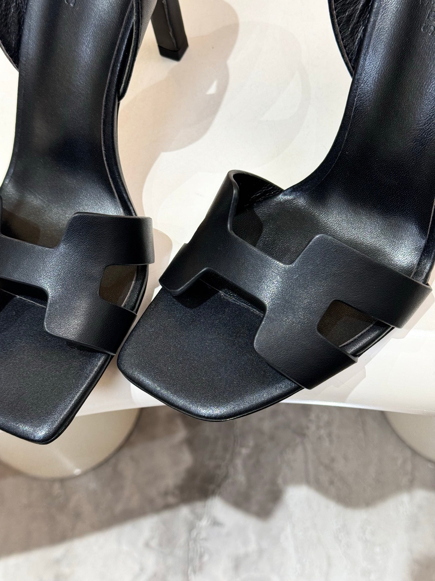 Close-up of black T-strap heeled sandal with adjustable buckle