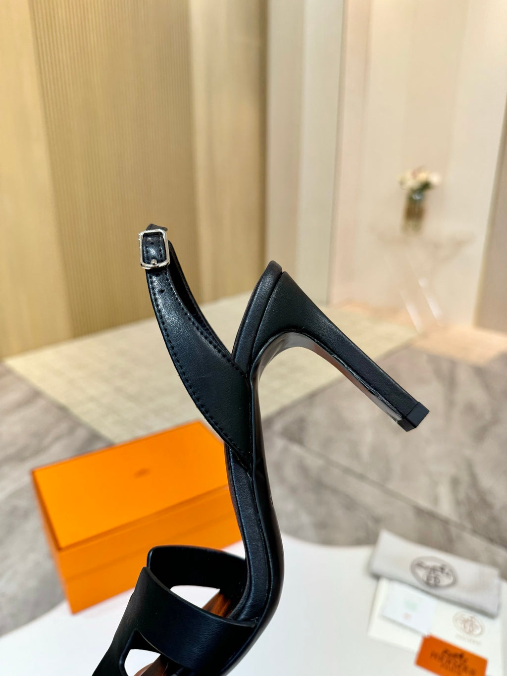 Black heeled sandal with ankle strap and slingback-style back loop