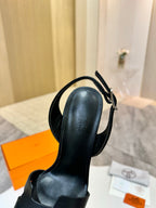 Black leather heeled sandal with slingback strap and metal buckle detail