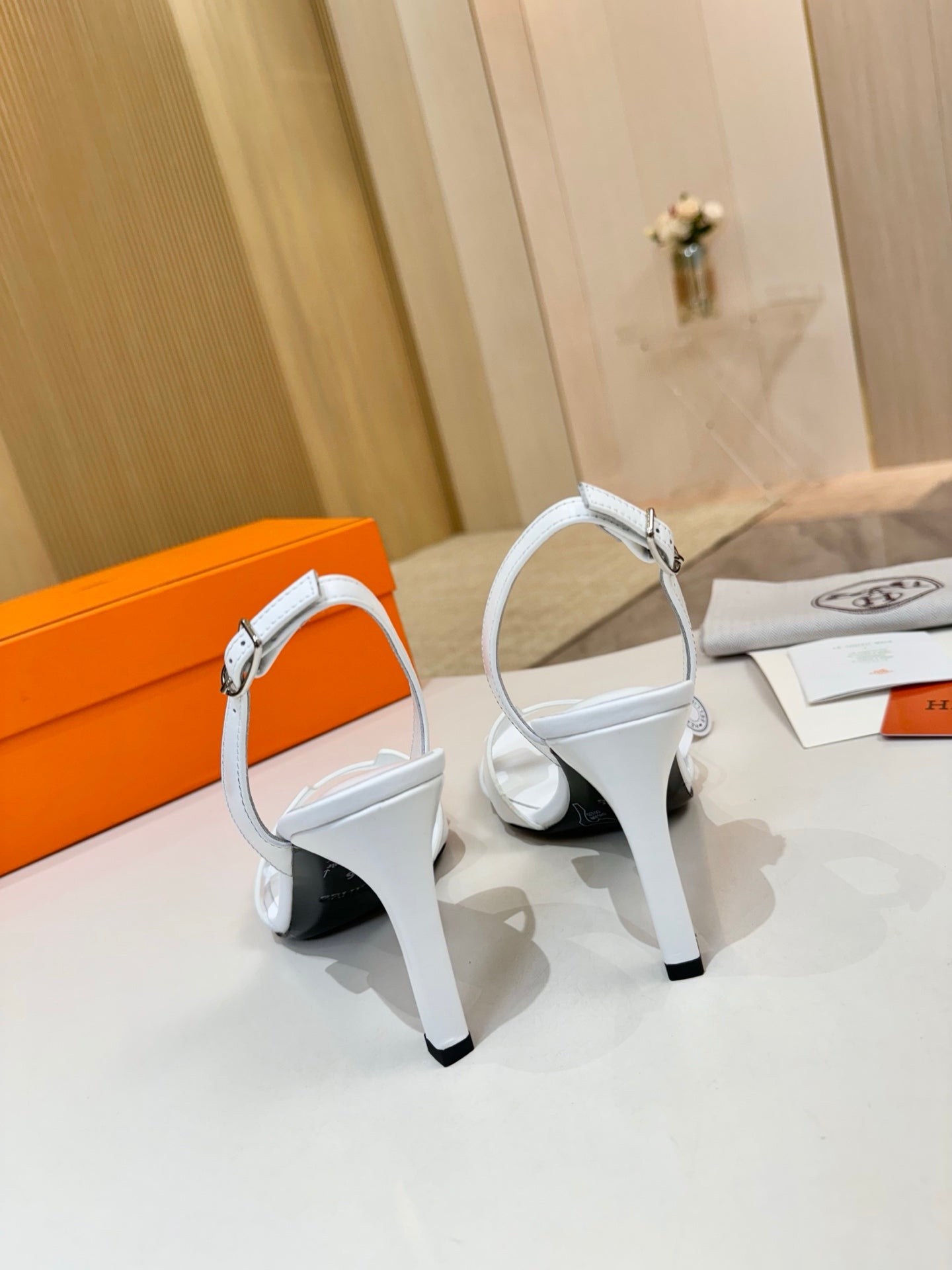 White heeled sandals with ankle straps and open toe, side view