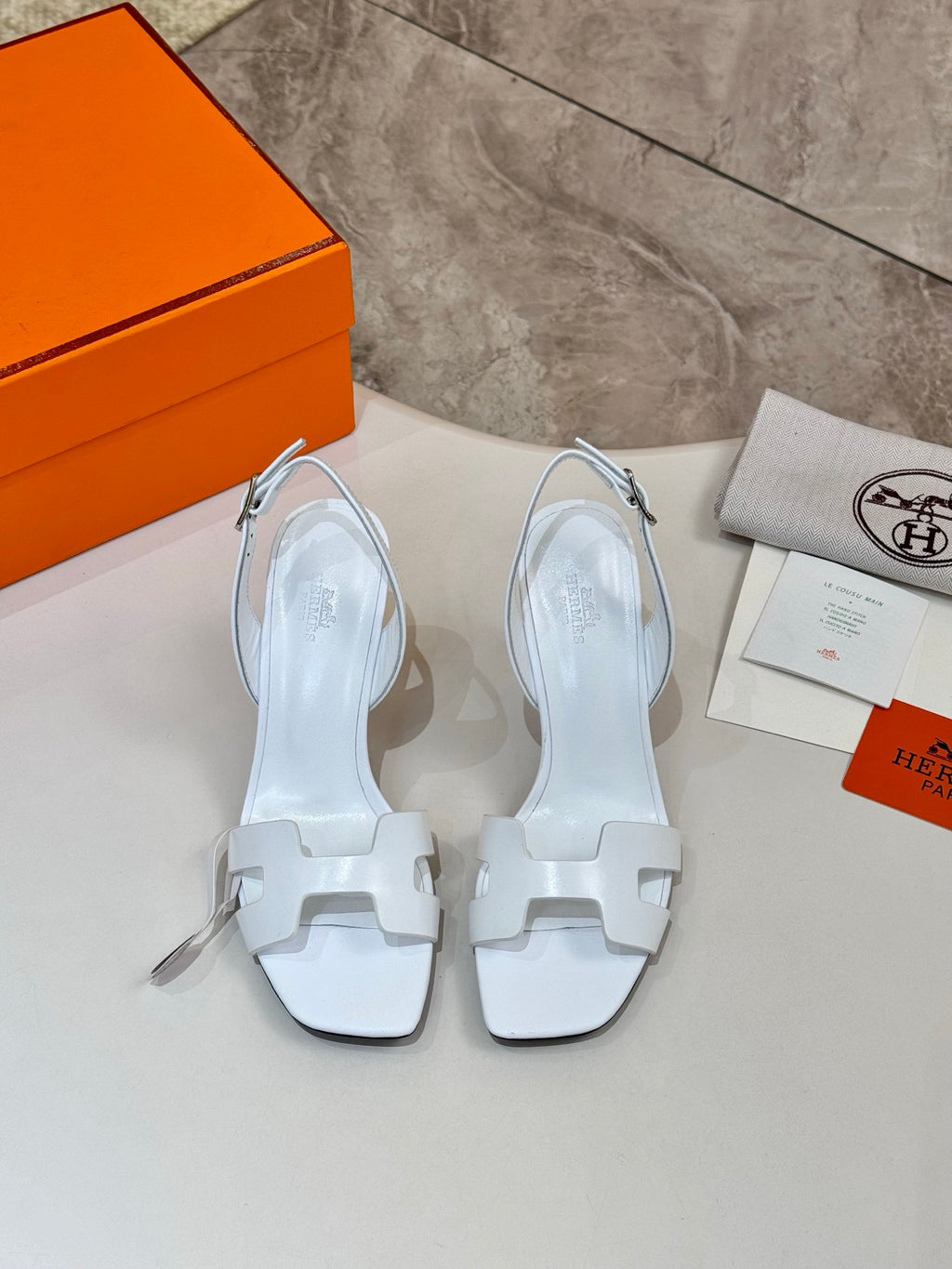Pair of white heeled sandals with cutout straps and open toe