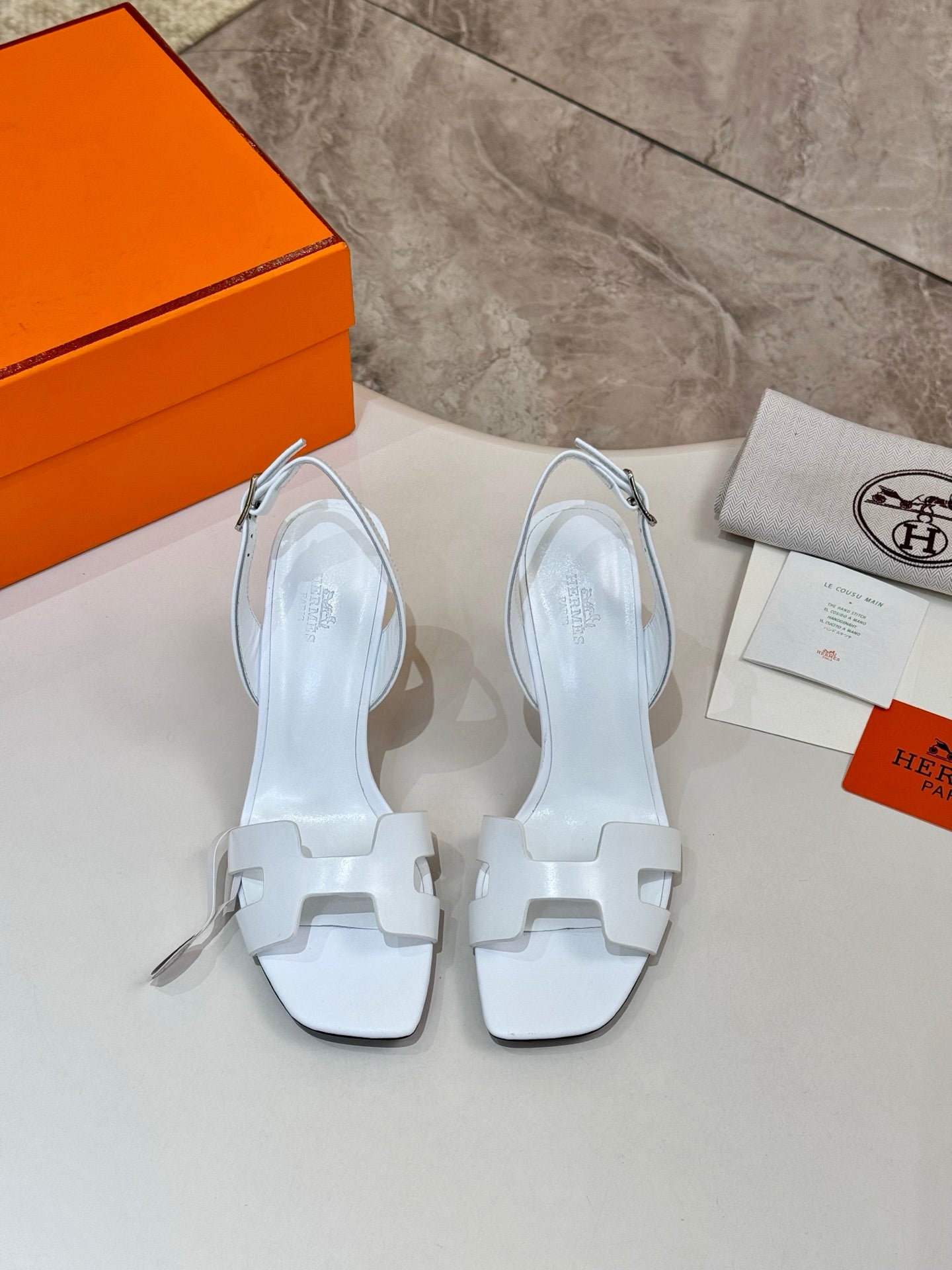 Pair of white heeled sandals with cutout straps and open toe