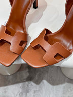 Brown leather heeled sandals close-up with openwork straps and T-strap detail