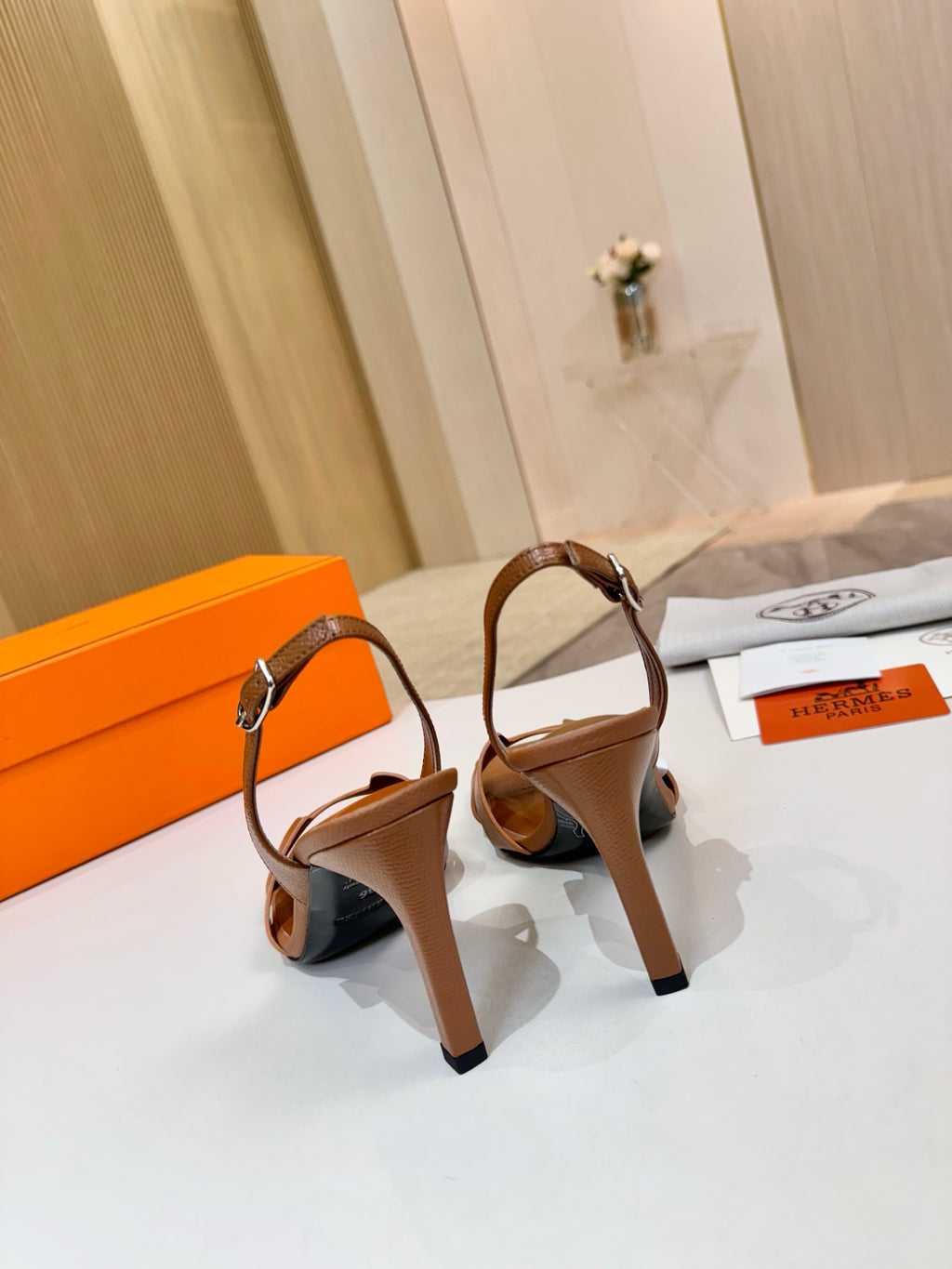 Brown leather heeled sandals with thin ankle strap and metal buckle hardware